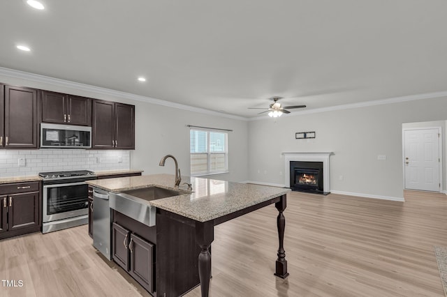 233 Stone River Dr, Wendell, NC 27591 - kitchen with light wood finished floors, a ceiling fan, tasteful backsplash, appliances with stainless steel finishes, and a sink