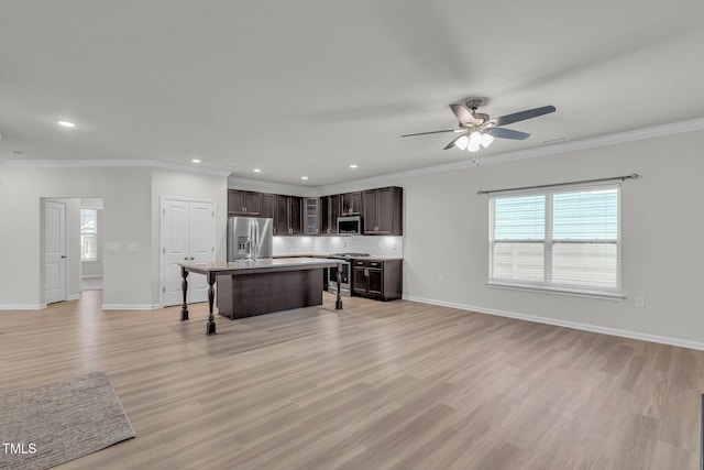 233 Stone River Dr, Wendell, NC 27591 - kitchen with tasteful backsplash, a kitchen bar, appliances with stainless steel finishes, ceiling fan, and dark brown cabinets