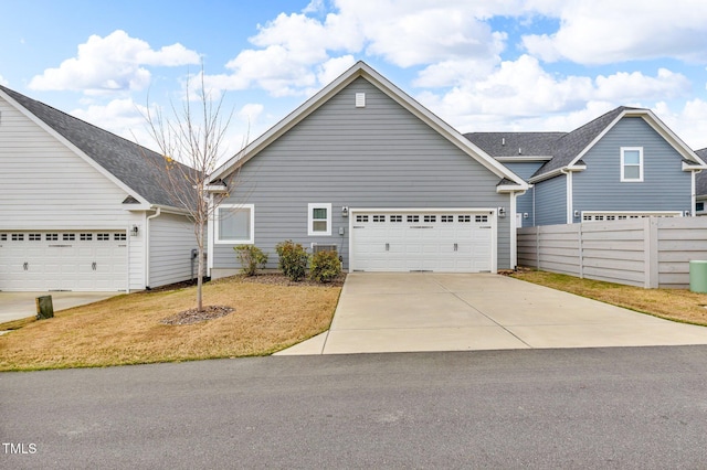 233 Stone River Dr, Wendell, NC 27591 - view of front of house featuring a front lawn, an attached garage, fence, and concrete driveway