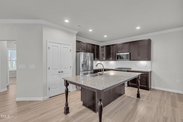 233 Stone River Dr, Wendell, NC 27591 - kitchen featuring decorative backsplash, stainless steel appliances, dark brown cabinets, a sink, and a breakfast bar area