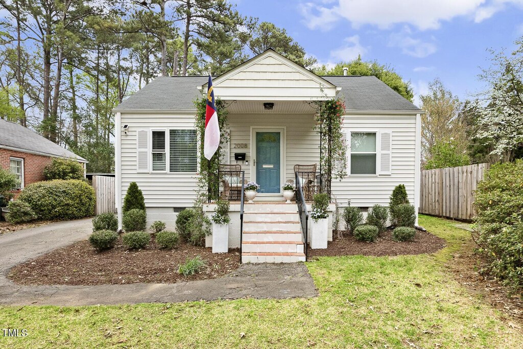 bungalow-style house featuring crawl space, roof with shingles, covered porch, and fence