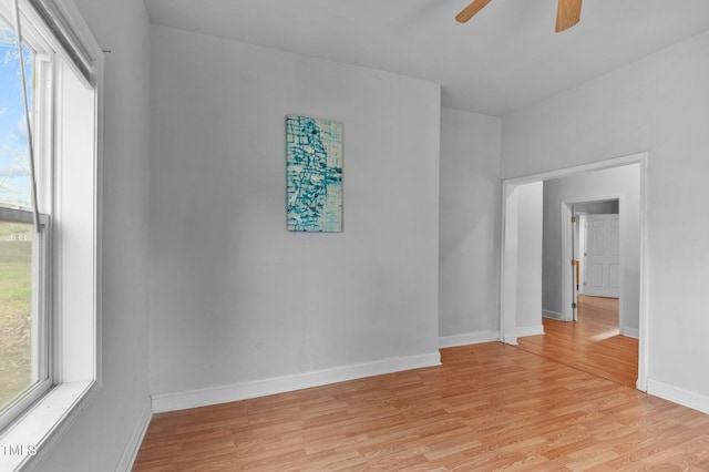 unfurnished room with light wood-style flooring, ceiling fan, and baseboards