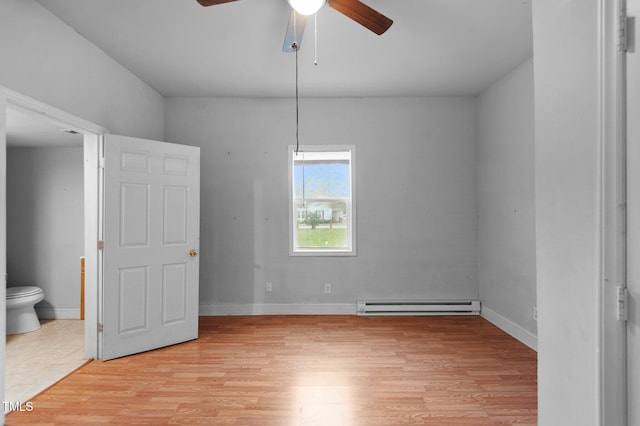 unfurnished bedroom with light wood-style flooring, a baseboard radiator, baseboards, and connected bathroom