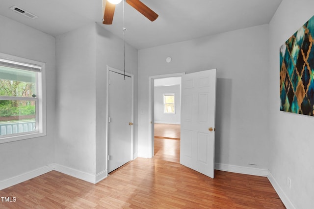 unfurnished bedroom featuring visible vents, light wood-type flooring, baseboards, and a ceiling fan