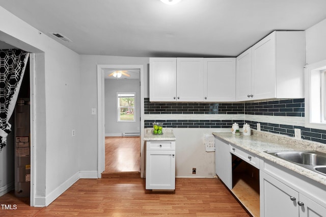 kitchen featuring white cabinets, light wood-style floors, and visible vents