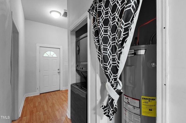 entryway with electric water heater, visible vents, light wood-type flooring, and baseboards