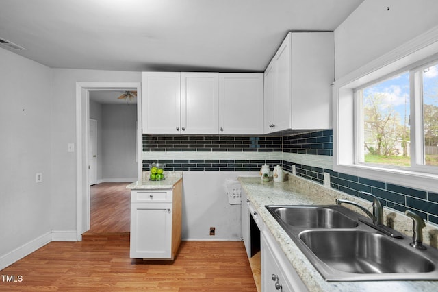 kitchen featuring visible vents, light wood-type flooring, a sink, and white cabinetry