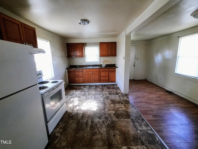 kitchen featuring visible vents, a sink, ventilation hood, dark countertops, and white appliances
