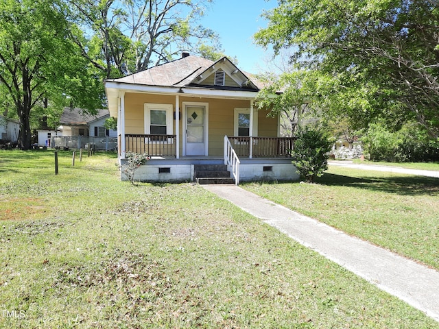 bungalow-style house featuring a porch, a front lawn, and crawl space