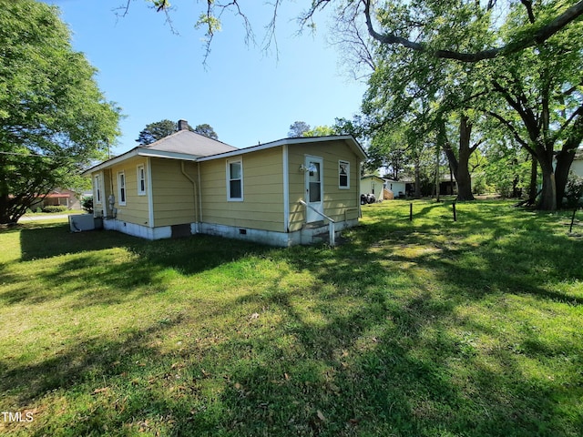 view of side of property with a lawn and crawl space