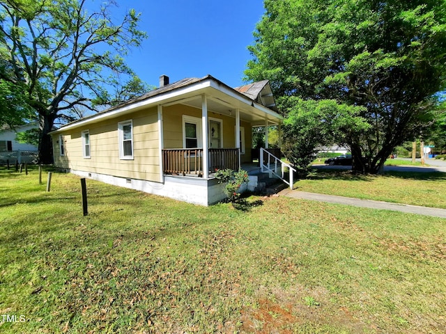 view of side of property featuring a porch, crawl space, and a lawn