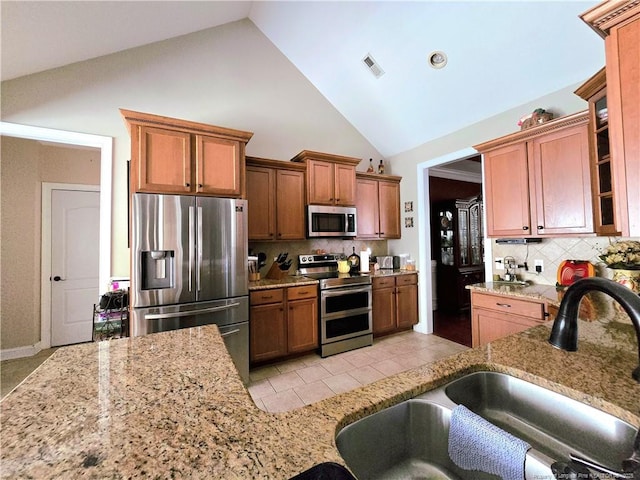 921 Satinwood Ct, Fayetteville, NC 28312 - kitchen with stainless steel appliances, a sink, decorative backsplash, light stone counters, and high vaulted ceiling