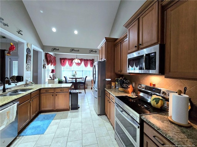 921 Satinwood Ct, Fayetteville, NC 28312 - kitchen with appliances with stainless steel finishes, a sink, vaulted ceiling, decorative backsplash, and light stone counters