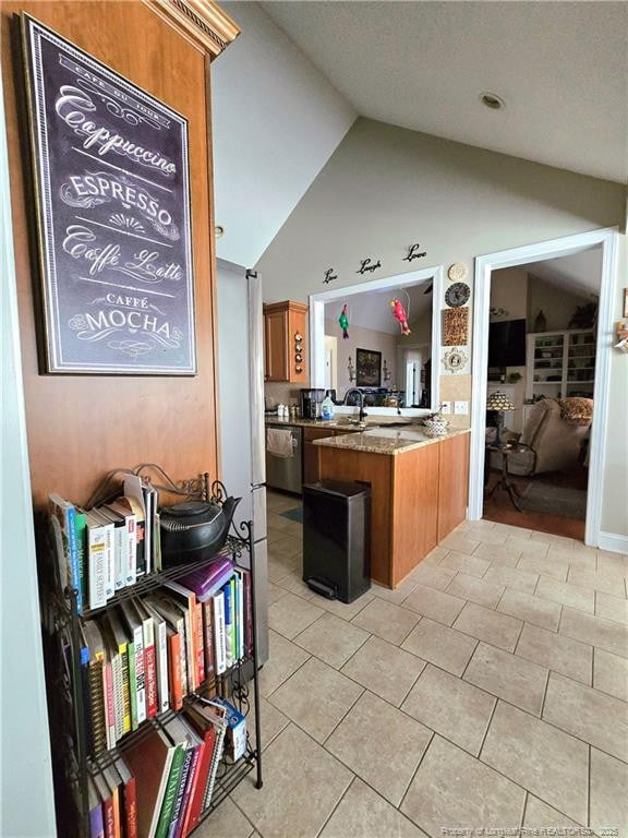 921 Satinwood Ct, Fayetteville, NC 28312 - kitchen with brown cabinets, stainless steel dishwasher, lofted ceiling, light tile patterned floors, and a peninsula