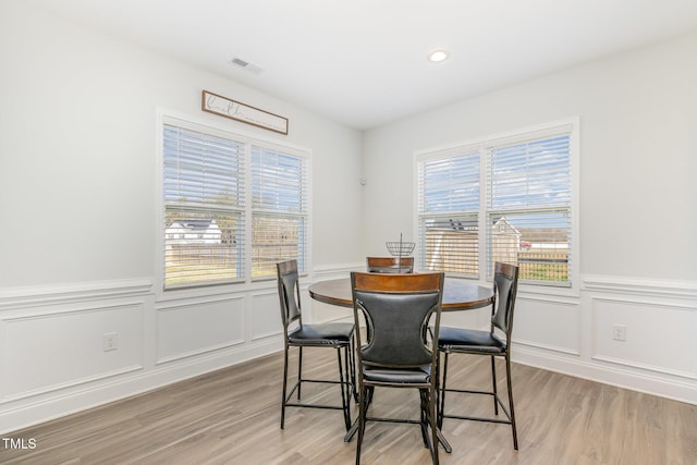 dining area featuring recessed lighting, visible vents, a wainscoted wall, and light wood-style flooring