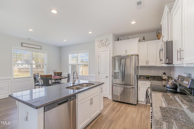 kitchen with a sink, visible vents, white cabinetry, and stainless steel appliances