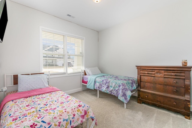 bedroom featuring visible vents, baseboards, and carpet