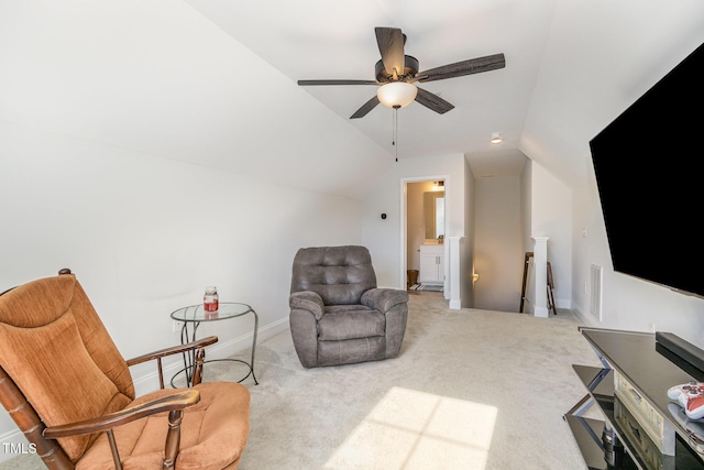 sitting room featuring ceiling fan, carpet, visible vents, vaulted ceiling, and an upstairs landing
