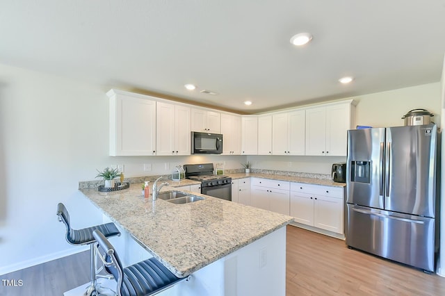 2065 Alderman Way, Creedmoor, NC 27522 - kitchen with light wood-type flooring, a sink, a peninsula, and black appliances