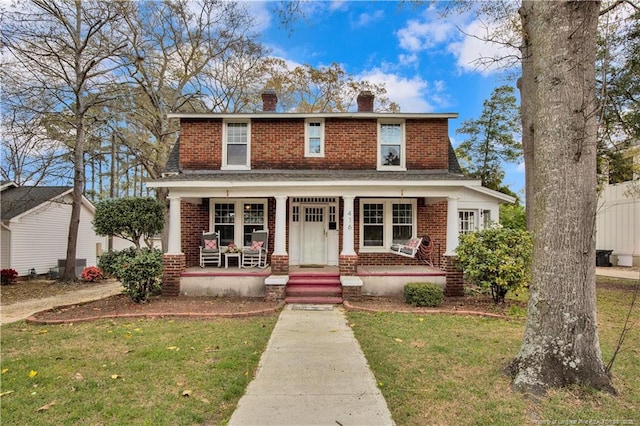 416 N Main St, Raeford, NC 28376 - view of front of house featuring brick siding, a porch, a chimney, and a front lawn