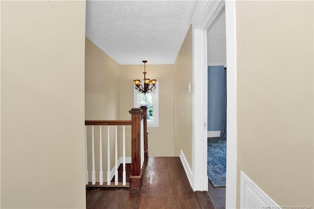 416 N Main St, Raeford, NC 28376 - hall with a notable chandelier, an upstairs landing, a textured ceiling, dark wood-type flooring, and visible vents