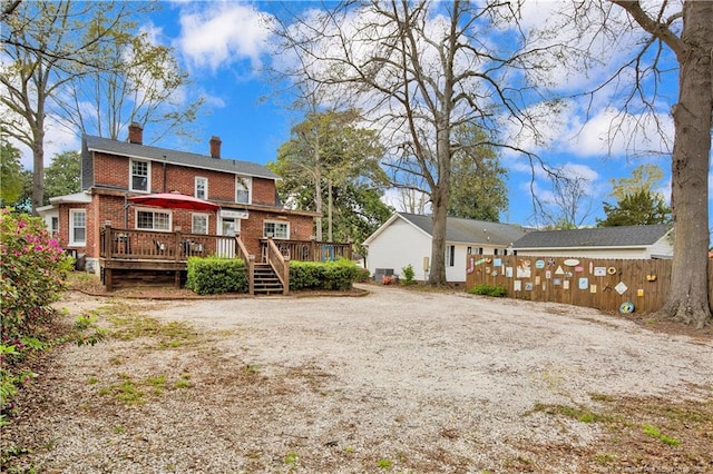 416 N Main St, Raeford, NC 28376 - back of house with a chimney, driveway, brick siding, a wooden deck, and fence