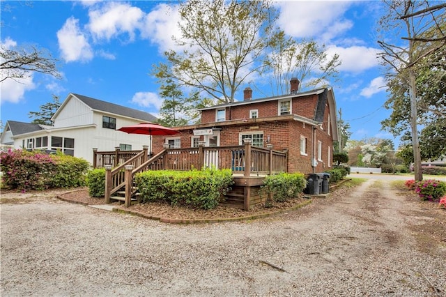 416 N Main St, Raeford, NC 28376 - rear view of house featuring a wooden deck, central AC, dirt driveway, brick siding, and a chimney