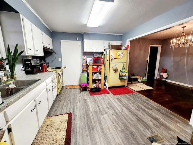 4017 Glenridge Rd, Fayetteville, NC 28304 - kitchen with white appliances, wood finished floors, light countertops, a sink, and white cabinets