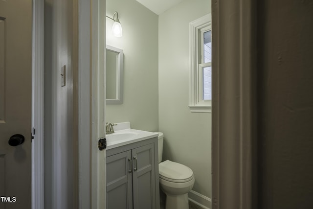 bathroom featuring baseboards, vanity, and toilet