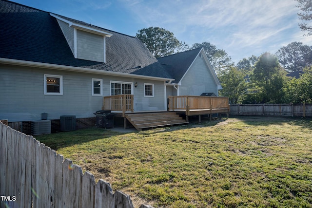 rear view of property featuring a fenced backyard, a wooden deck, cooling unit, and a lawn