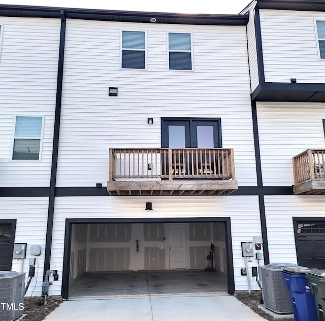 413 Diversity Way, Raleigh, NC 27610 - back of house with a garage, central AC, concrete driveway, and a balcony