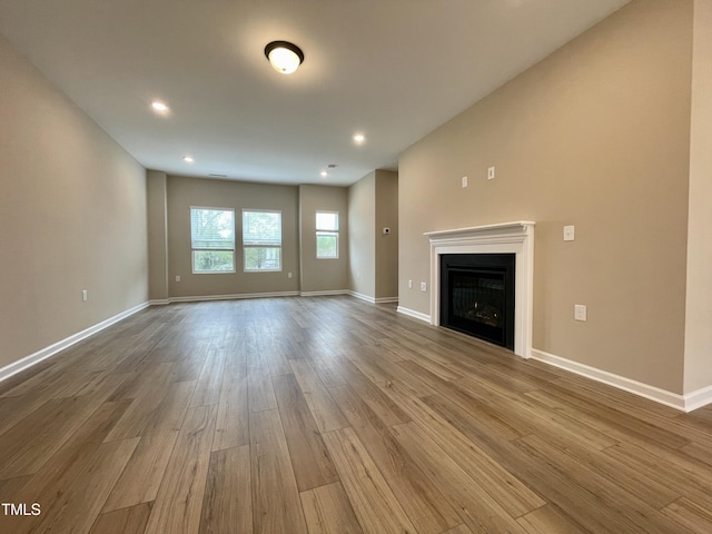413 Diversity Way, Raleigh, NC 27610 - unfurnished living room with wood finished floors, baseboards, a fireplace, and recessed lighting