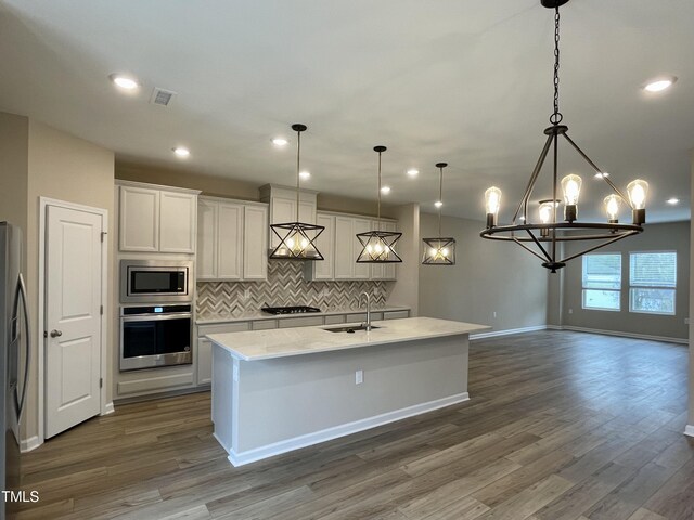 413 Diversity Way, Raleigh, NC 27610 - kitchen featuring appliances with stainless steel finishes, a sink, wood finished floors, tasteful backsplash, and recessed lighting