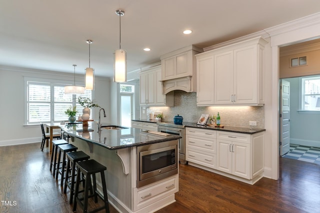 721 Shelley Rd, Raleigh, NC 27609 - kitchen featuring stainless steel microwave, backsplash, a wealth of natural light, and a sink