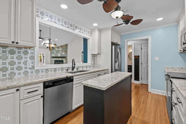 104 Chuckwagon Dr, Louisburg, NC 27549 - kitchen featuring a sink, a center island, white cabinets, a ceiling fan, and appliances with stainless steel finishes