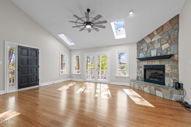 104 Chuckwagon Dr, Louisburg, NC 27549 - unfurnished living room featuring a stone fireplace, baseboards, and a skylight