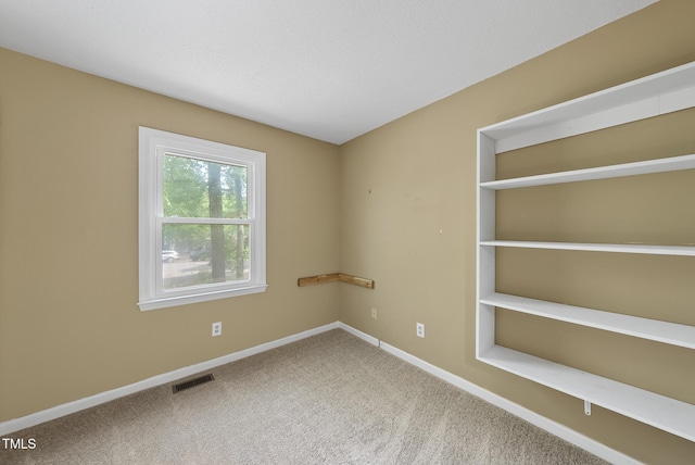 unfurnished room with visible vents, carpet flooring, and baseboards