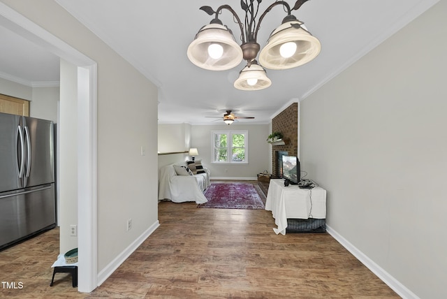 hall featuring wood finished floors, baseboards, and ornamental molding