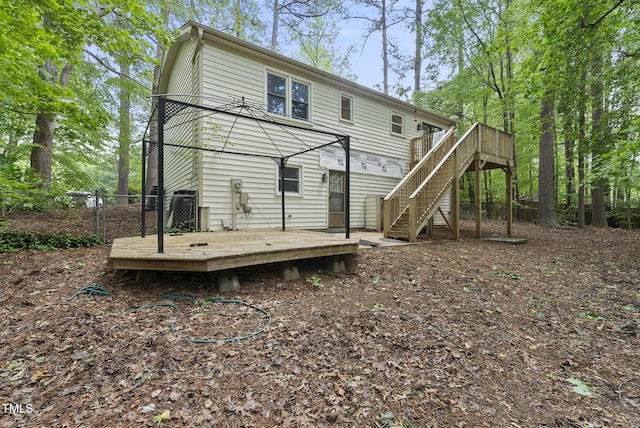 back of property with a deck and stairs
