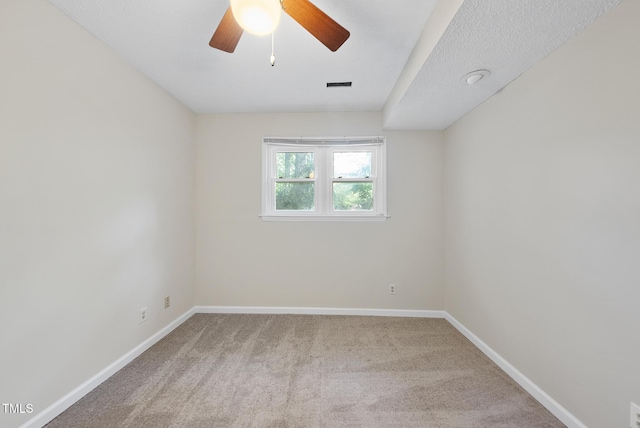 carpeted empty room with visible vents, baseboards, and ceiling fan