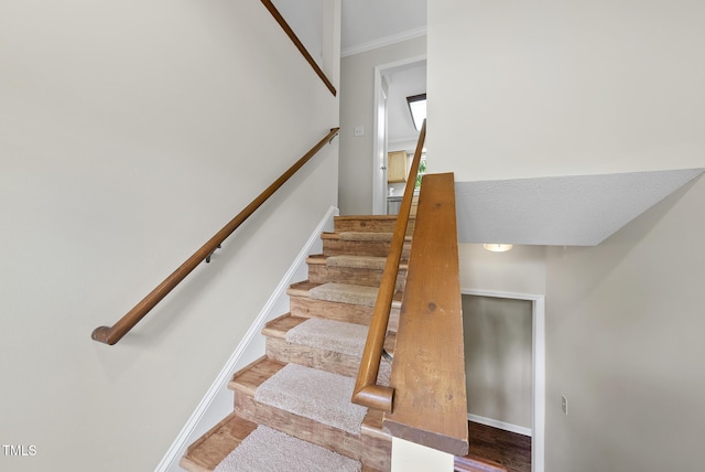 stairway with wood finished floors and baseboards