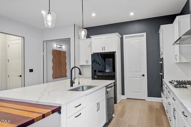 956 The Parks Dr, Pittsboro, NC 27312 - kitchen featuring light wood-style floors, wall chimney range hood, white cabinetry, appliances with stainless steel finishes, and a sink