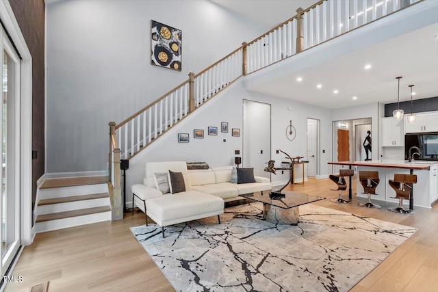 956 The Parks Dr, Pittsboro, NC 27312 - living area featuring light wood-style floors, a high ceiling, recessed lighting, and stairs