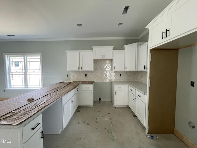 502 S Vance St, Fremont, NC 27830 - kitchen featuring tasteful backsplash, crown molding, unfinished concrete flooring, white cabinets, and a peninsula