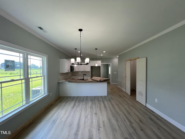 502 S Vance St, Fremont, NC 27830 - kitchen with a chandelier, crown molding, a peninsula, white cabinetry, and wood finished floors