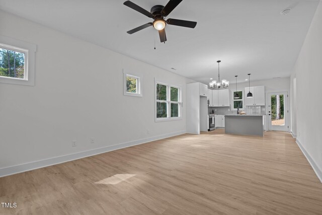 111 Halifax Rd, Louisburg, NC 27549 - unfurnished living room featuring light wood-style flooring, baseboards, and ceiling fan with notable chandelier