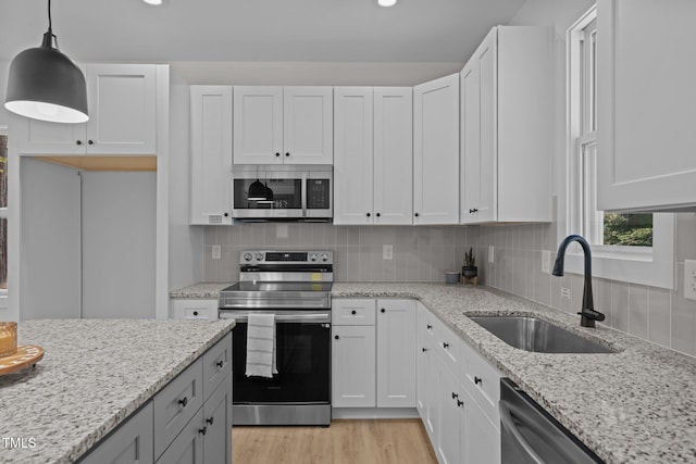 111 Halifax Rd, Louisburg, NC 27549 - kitchen with white cabinetry, backsplash, stainless steel appliances, light wood finished floors, and a sink