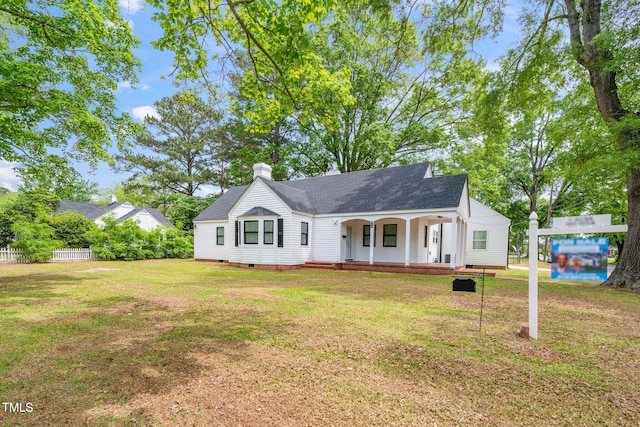 view of front of house with a front lawn, a chimney, a shingled roof, crawl space, and a porch