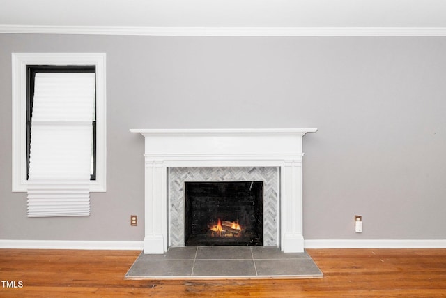 details with baseboards, ornamental molding, wood finished floors, and a fireplace