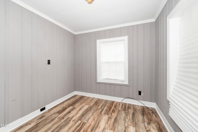 unfurnished room featuring baseboards, crown molding, and wood finished floors